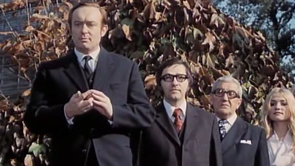 Oldřich Unger (první zleva) jako předseda výstavního výboru ve filmu Jáchyme hoď ho do stroje (1974)