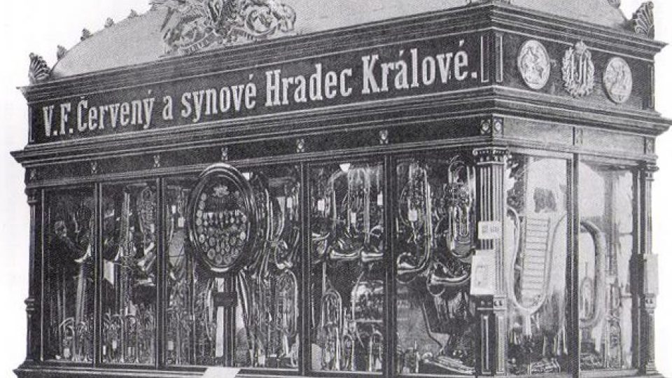 Expozice hudebních nástrojů firmy V. F. Červený a synové ve vitríně inspirované budovou Národního divadla