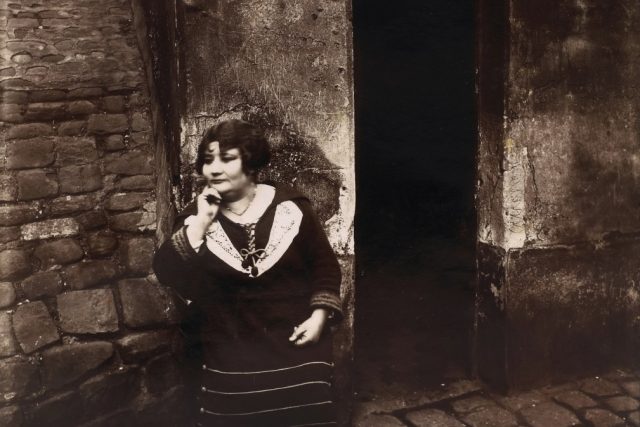 Prostitutka čeká před dveřmi domu na zákazníka | foto: Eugène Atget