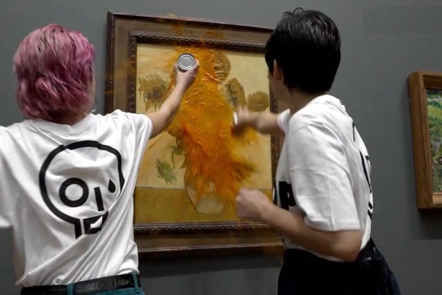 Aktivistky v Londýně nejprve polily obraz rajčatovou polévkou a pak se přilepily ke stěně | foto: Profimedia