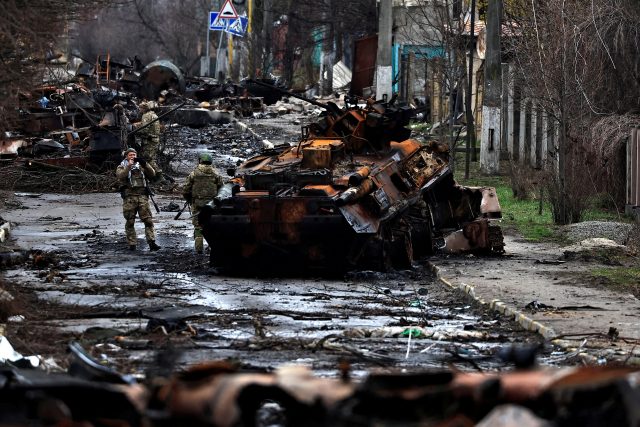 Voják pózuje u ruského zničeného tanku a obrněných vozidel ve městě Buča poblíž Kyjeva | foto: Reuters