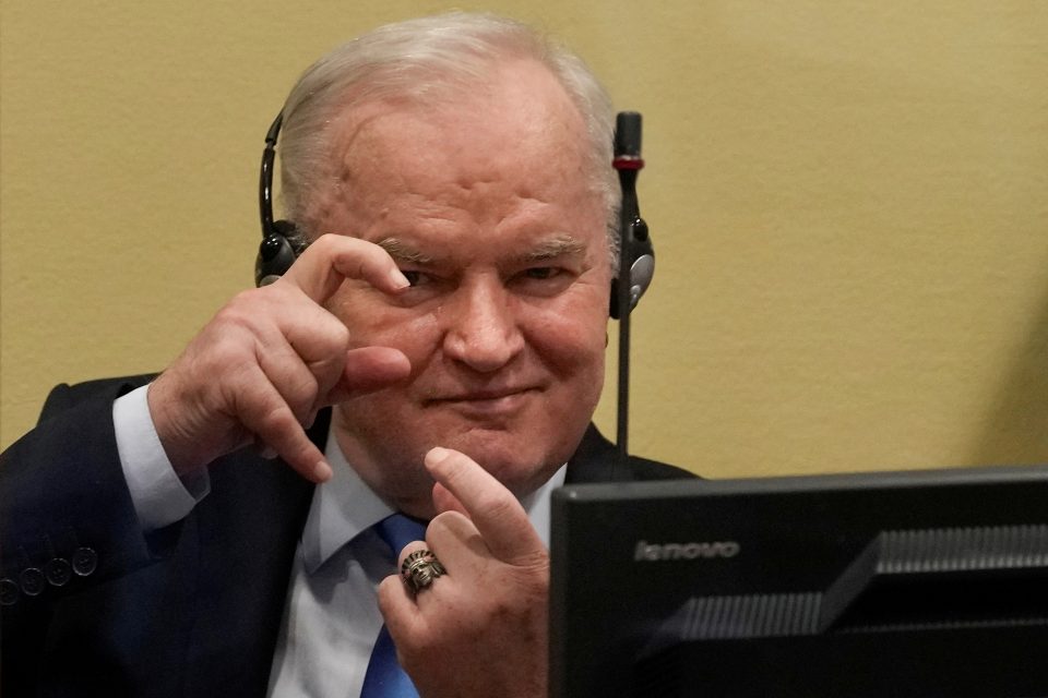 Ratko Mladić v soudní síni 8. 6. 2021. Na přítomné fotografy reagoval gestem imitujícím focení | foto: Peter Dejong,  Reuters